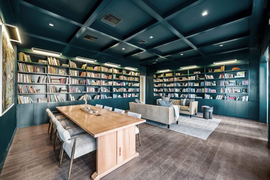 A room with a long table surrounded by bookshelves filled with books.