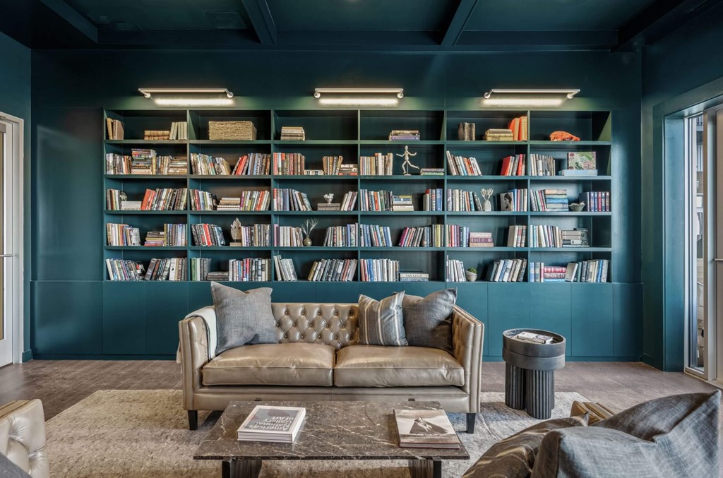 A living room with a couch, a coffee table, and a bookshelf filled with books.