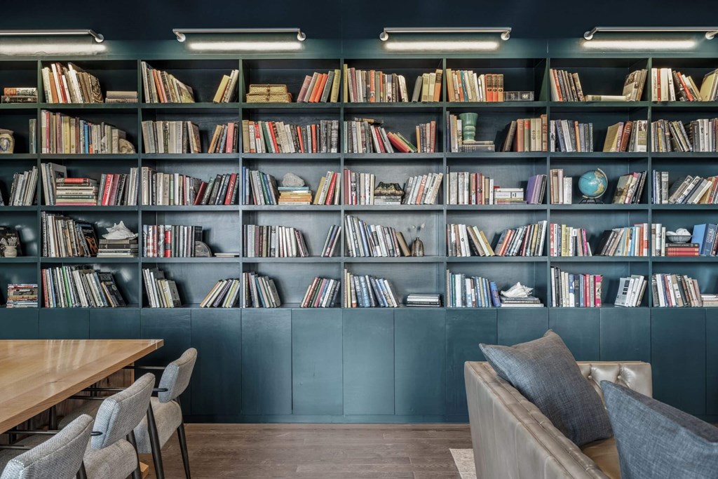 A room with a bookshelf filled with books and a table with chairs.
