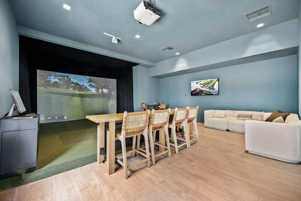 A room with a table and chairs and a television on the wall.