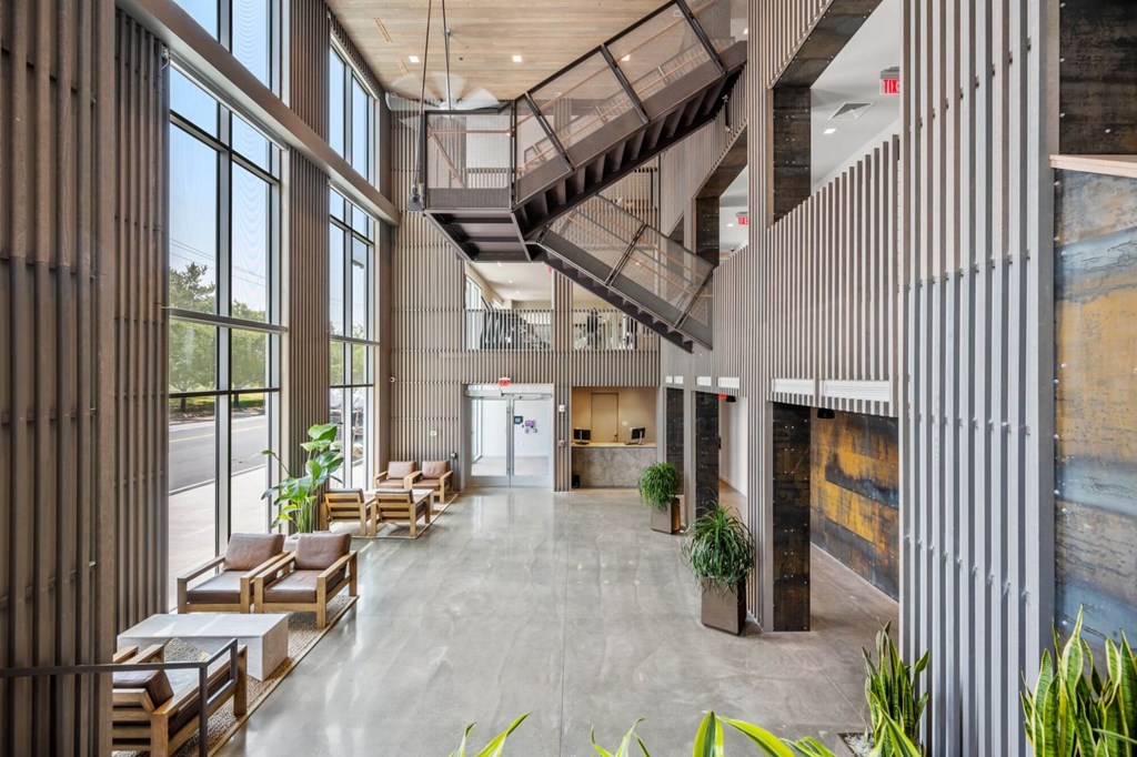 A modern atrium with a staircase and seating area.