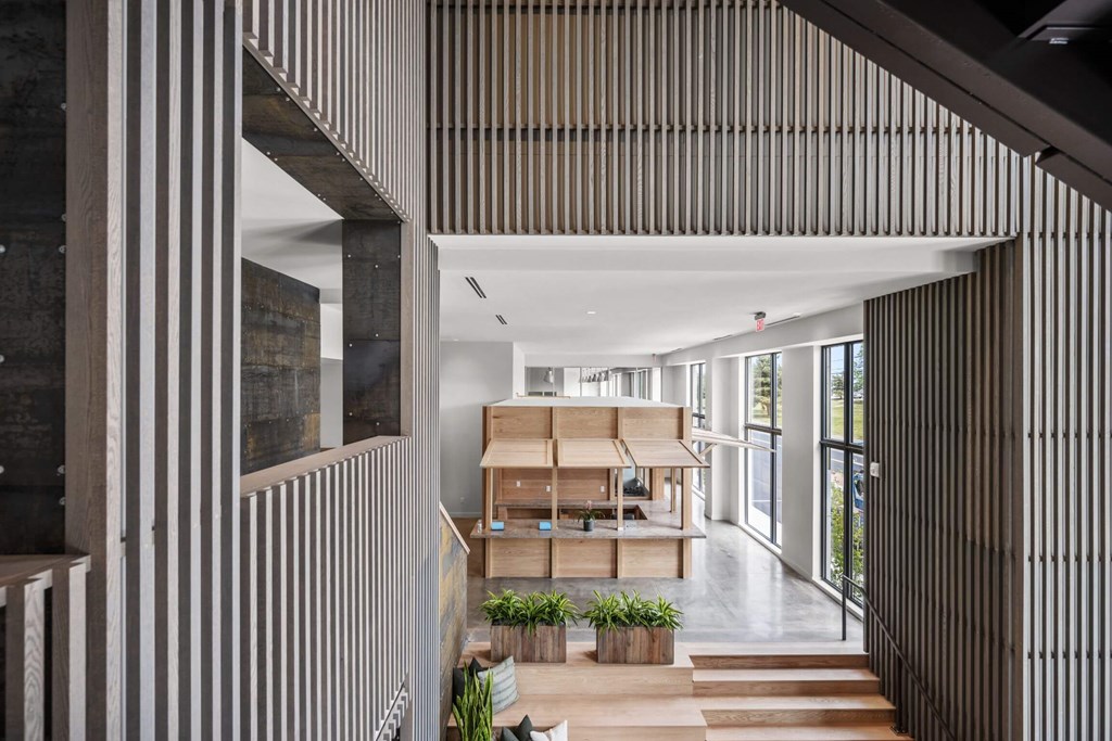 A modern interior with a long hallway and a staircase on the left.