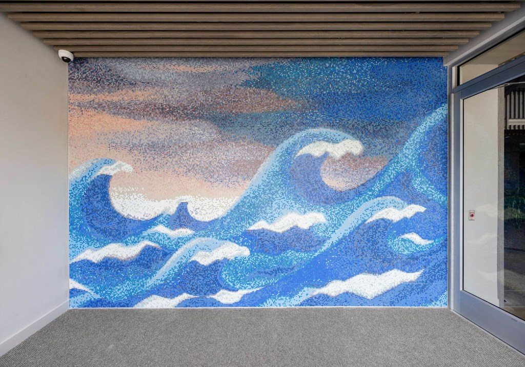 A painting of blue waves on a wall.