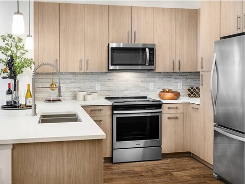 A modern kitchen with wooden cabinets and stainless steel appliances.