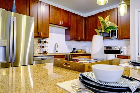 A modern kitchen with a stainless steel refrigerator and wooden cabinets.
