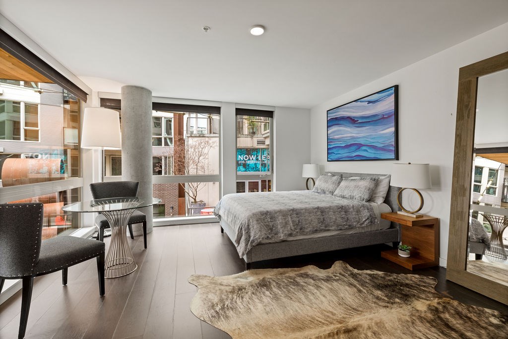 A bedroom with a large bed and a chair.