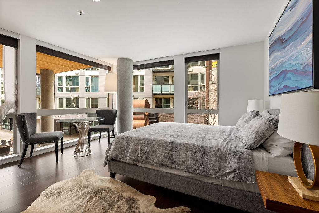 A bedroom with a large bed and a table with chairs.