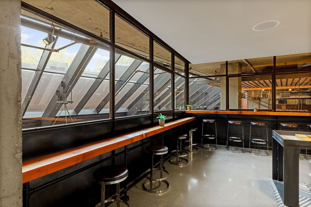 A bar with a long wooden counter and stools is shown.