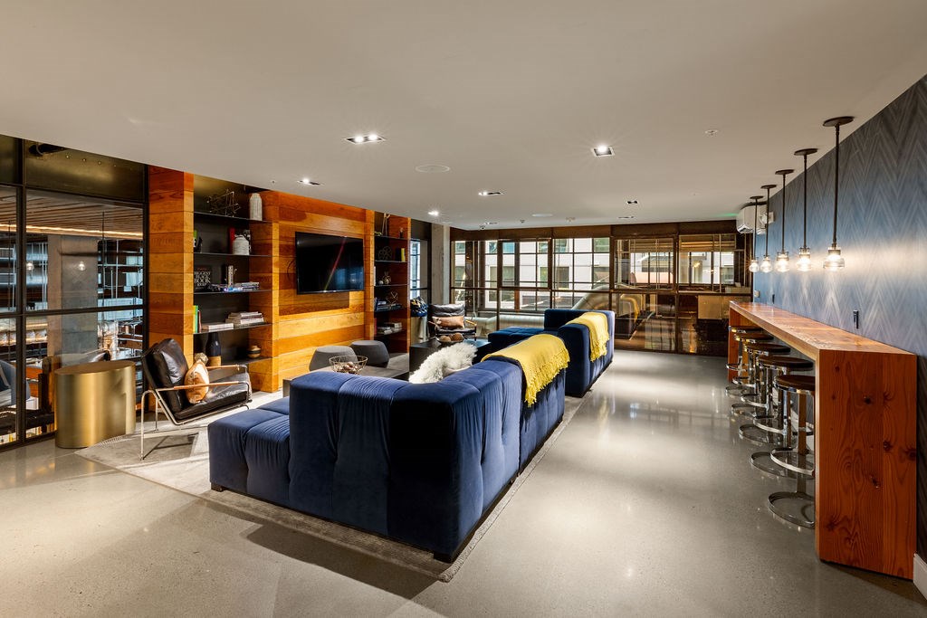 A modern living room with a blue sofa and a wooden bar.