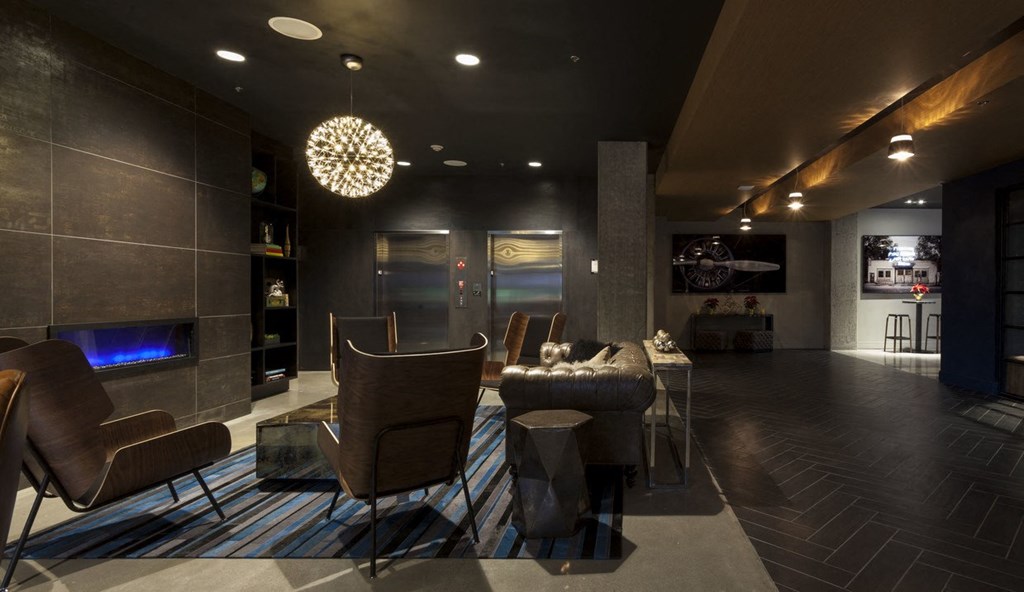 Community Lounge with Armchairs, Fireplace, and Overhead Lighting