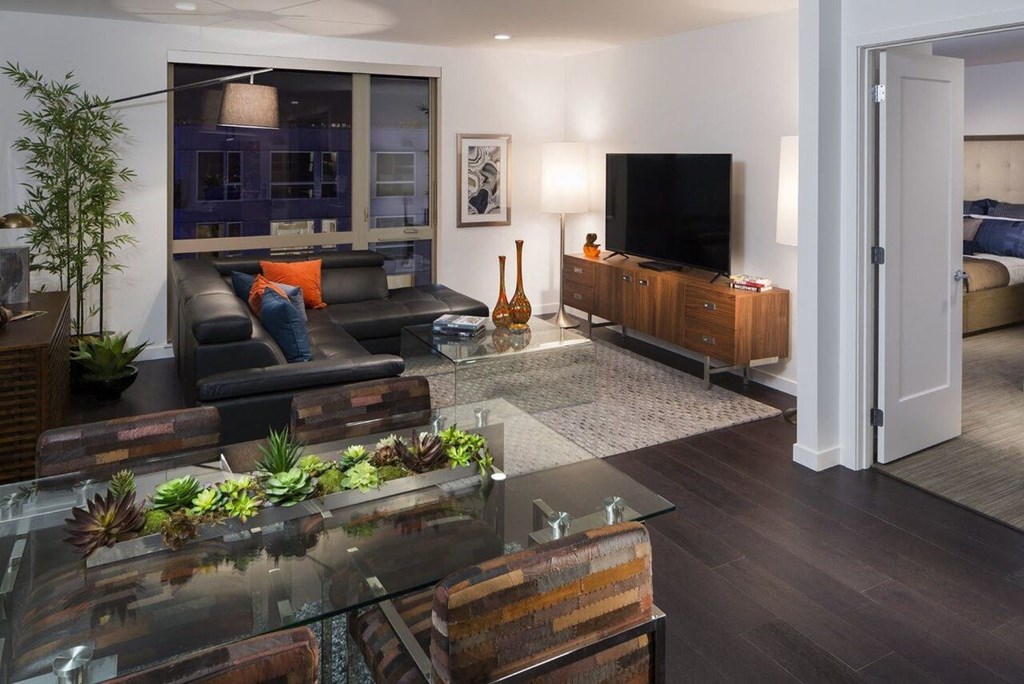 Living Space with Wall-Mounted TV, Dining Table, and Bedroom Access