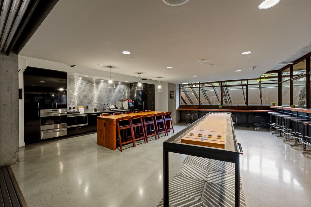 A shiny white floor with a long table and chairs in a room.