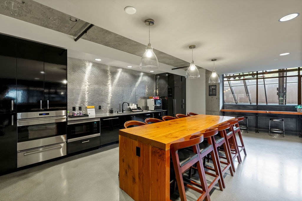 A modern kitchen with a wooden island and stainless steel appliances.