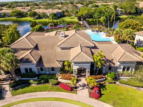 Aerial view of the clubhouse at San Merano at Mirasol, its barrel tile roof, the resort pool and the lake beyond.