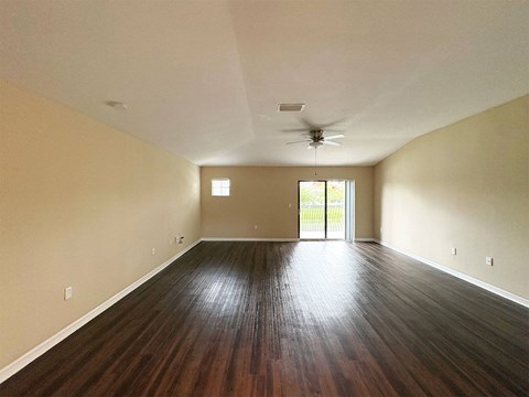 A room with wooden floors and a ceiling fan.