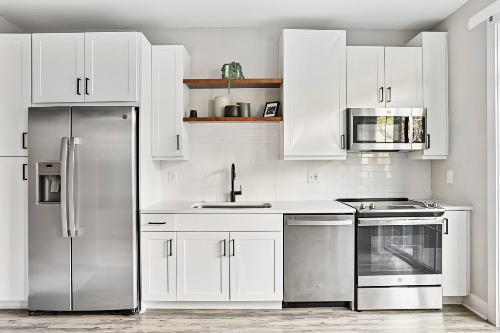 A modern kitchen with a stainless steel refrigerator and oven.