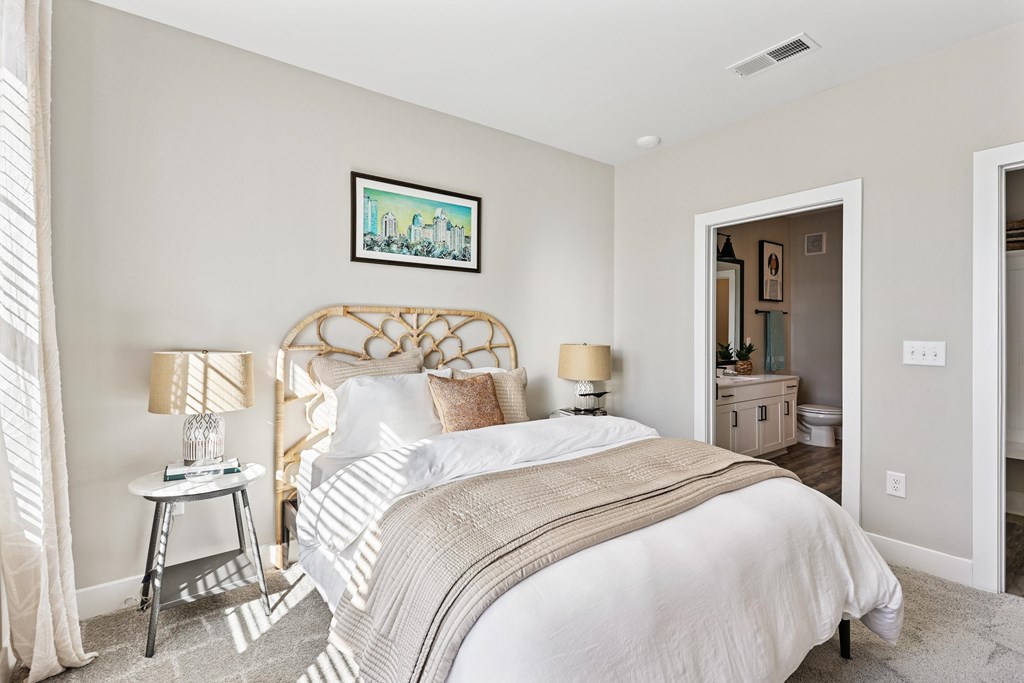 A bedroom with a large bed and a painting on the wall.