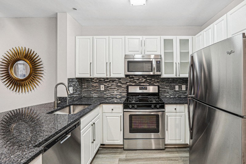 a kitchen with stainless steel appliances and white cabinets