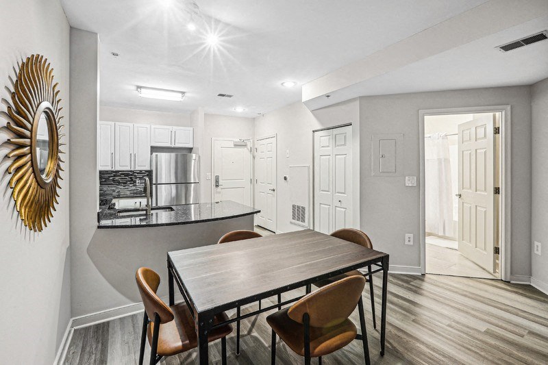 Open Layout with View of Kitchen, Dining Table, and Apartment Entrance