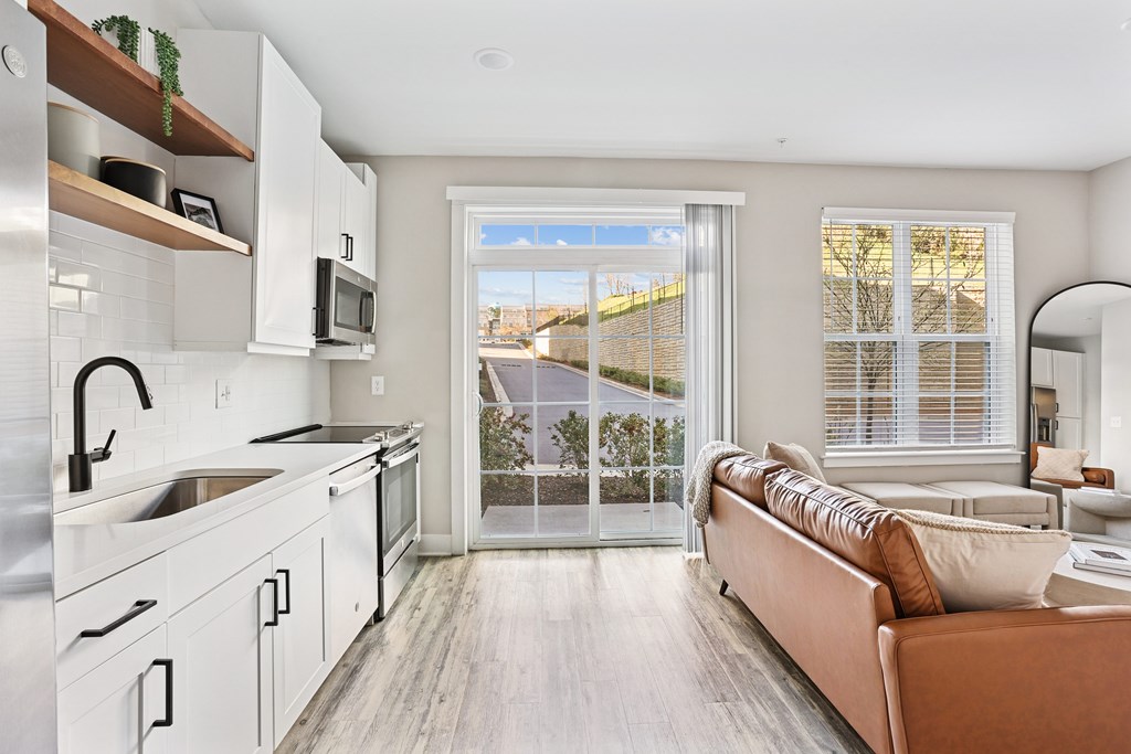 A modern kitchen with a couch and a view of the outside.