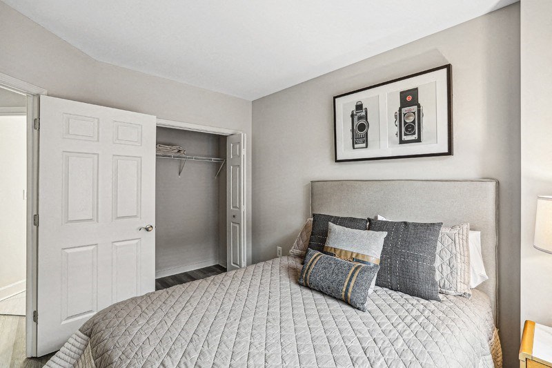 Apartment Bedroom Featuring Double Door Closet and Upholstered Bed