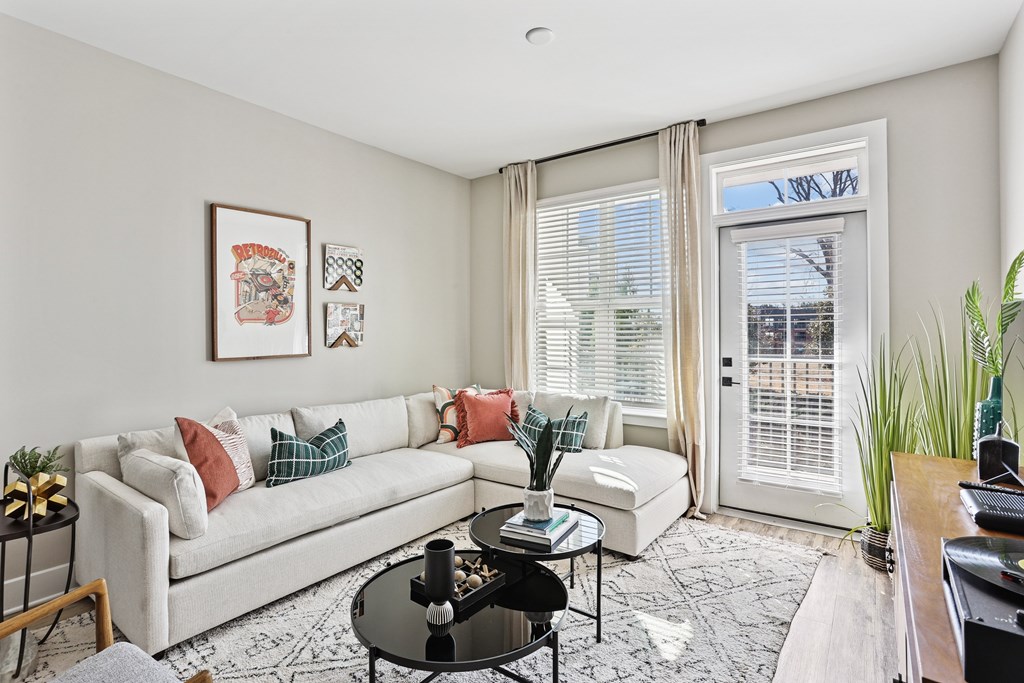 A living room with a white couch, a coffee table, and a rug.