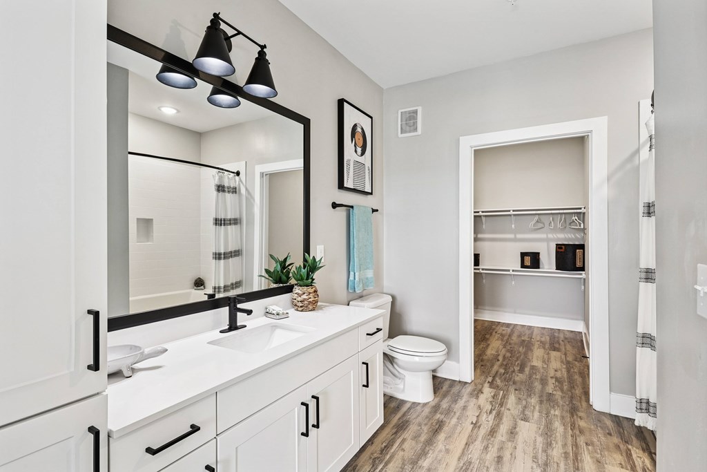 A bathroom with a white vanity and a toilet in the background.