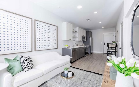 a living room with a couch and a kitchen