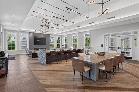 Clubhouse kitchen with a granite island seating six, bar stools, a gas fireplace and a long communal dining table.