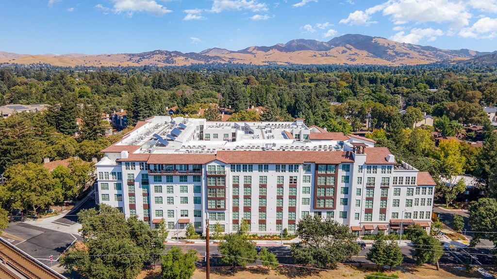 Aerial view of a modern Mediterranean-inspired apartment community with Mt. Diablo in the backdrop