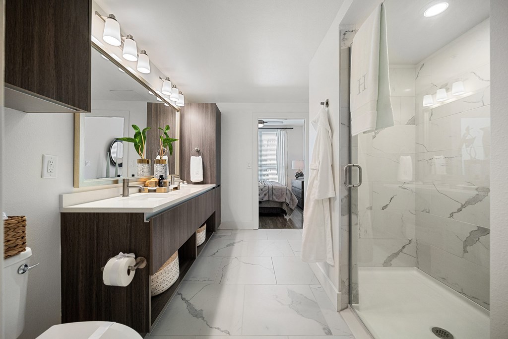 Spa-inspired bathroom with dual vanity, quartz counters, and a walk-in glass shower