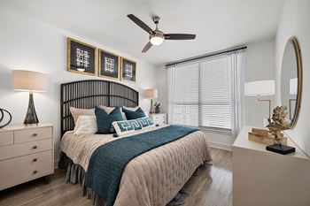 Serene bedroom with a statement headboard, ceiling fan, and oversized window for soft natural light