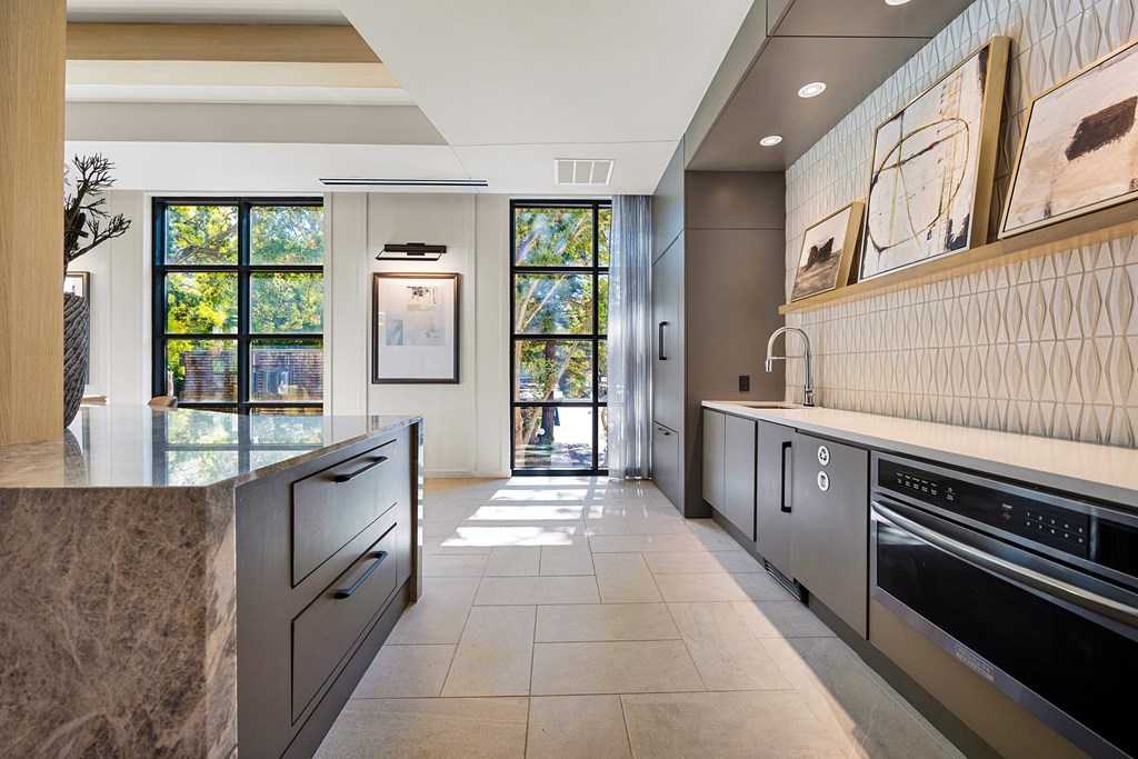 Chef-inspired catering kitchen with quartz countertops, modern cabinetry, and statement backsplash
