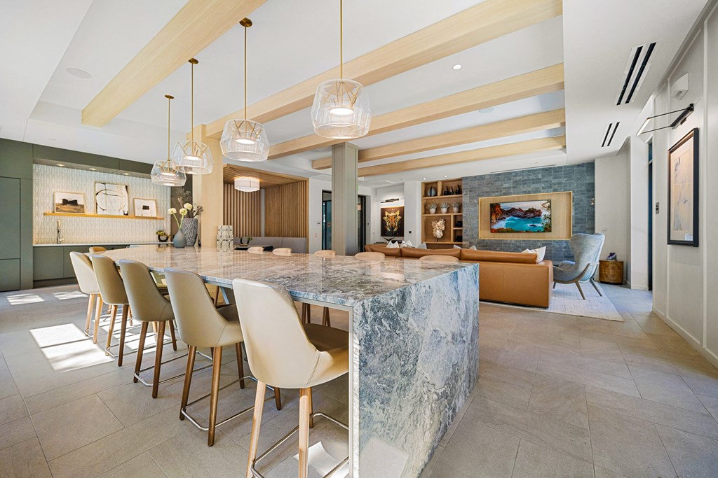 Entertaining space with a dramatic stone island, chic pendant lighting, and seamless flow into lounge seating