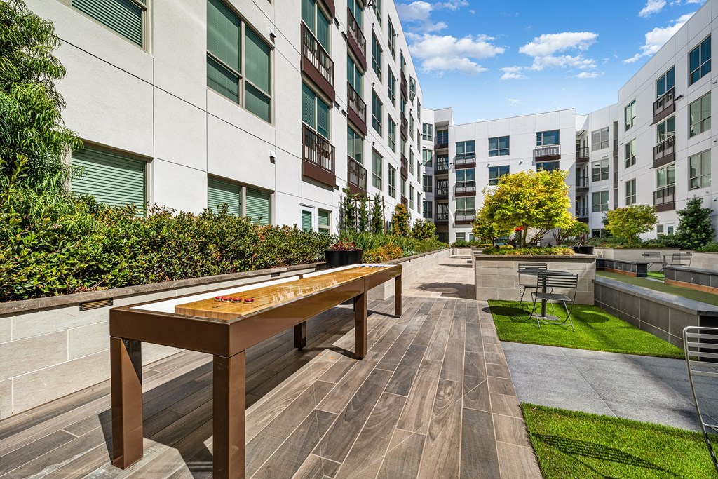Outdoor shuffleboard table on a landscaped terrace designed for relaxed afternoons and social fun