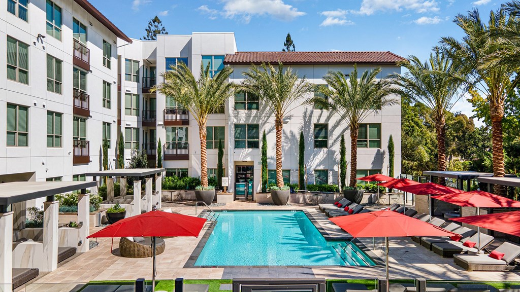 Shaded cabana seating with modern wicker furniture and ceiling fans for breezy afternoons by the pool