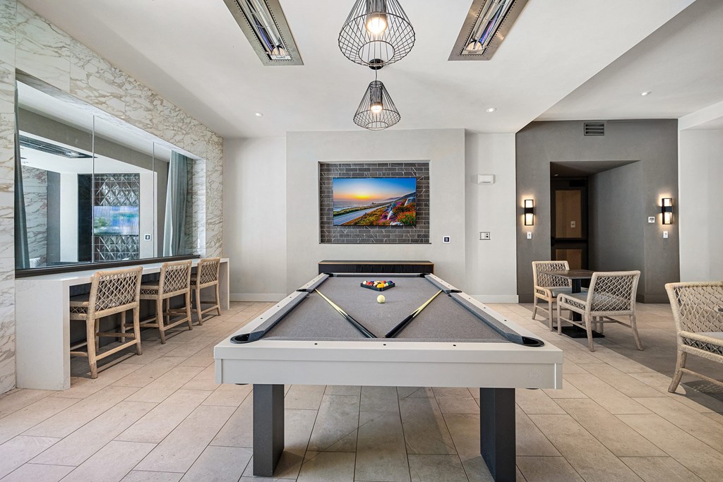 Game lounge featuring a billiards table, bar seating, and TVs for lively nights with friends