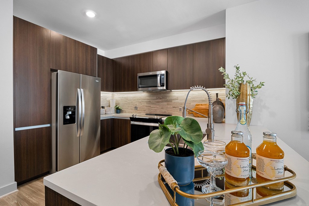 Designer kitchen featuring stainless steel appliances, modern fixtures, and a polished island centerpiece