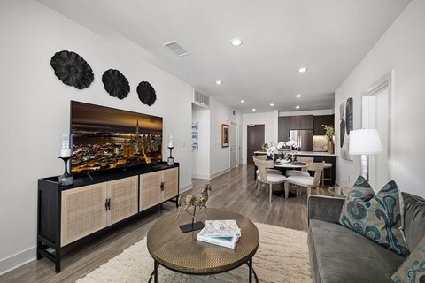 A modern living room with a wooden coffee table and a grey couch.