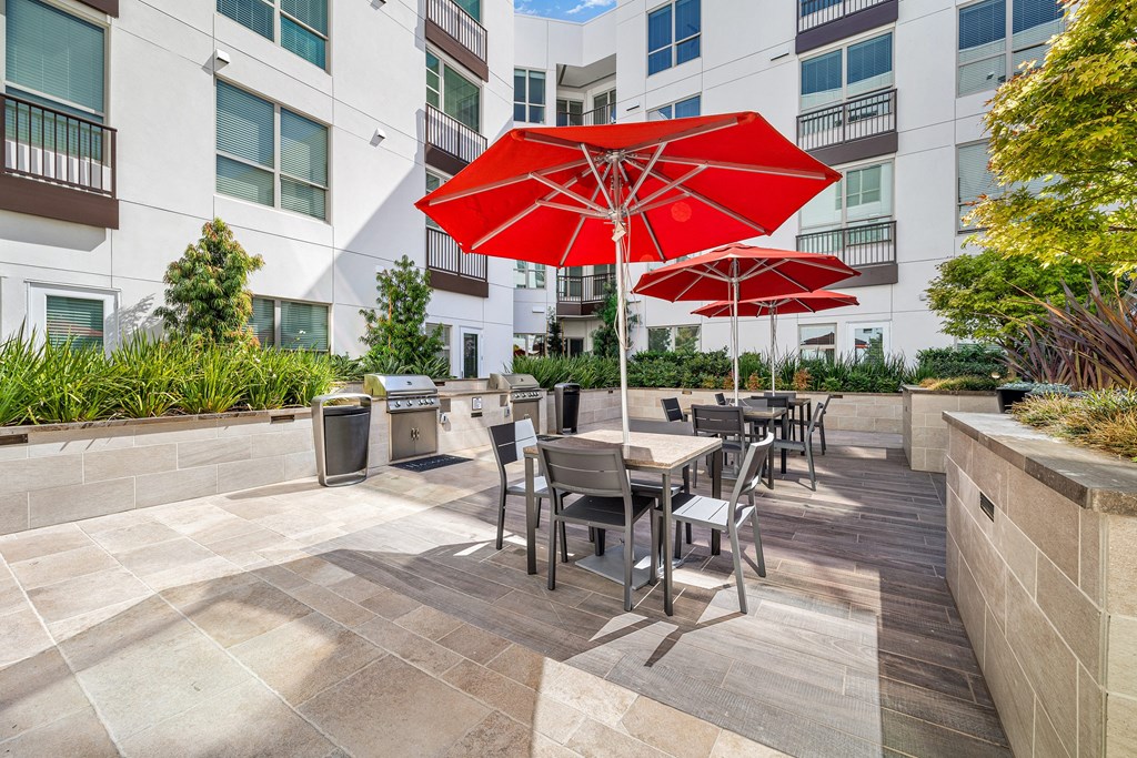Grilling and dining area with red umbrellas, stylish seating, and professional-grade barbecues for effortless entertaining