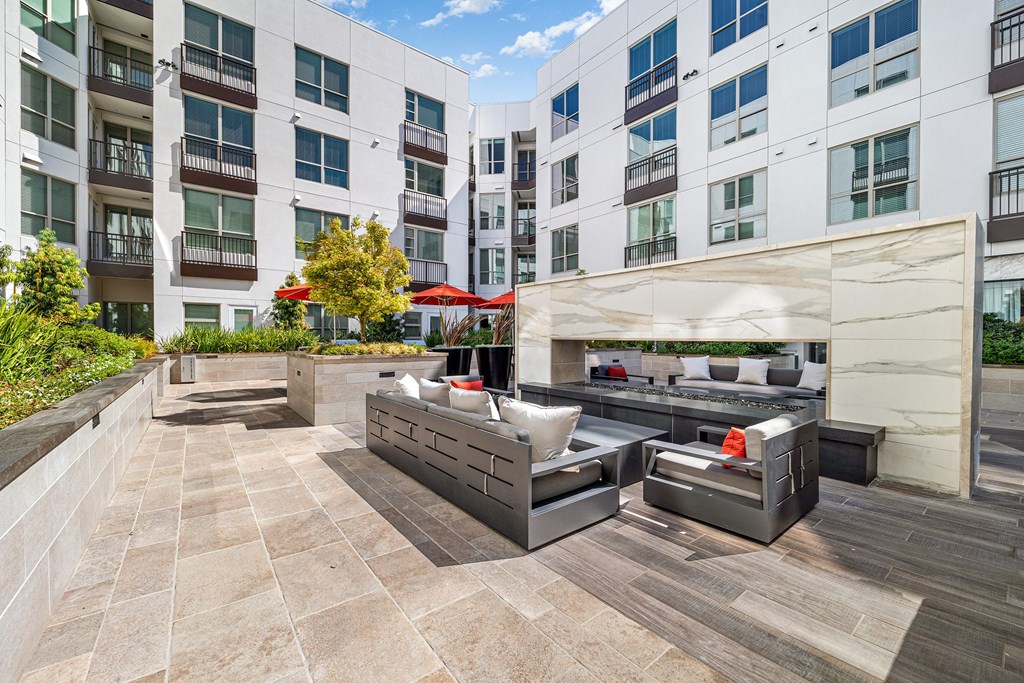 Contemporary outdoor lounge with sleek seating gathered around a double-sided fireplace for cozy evenings