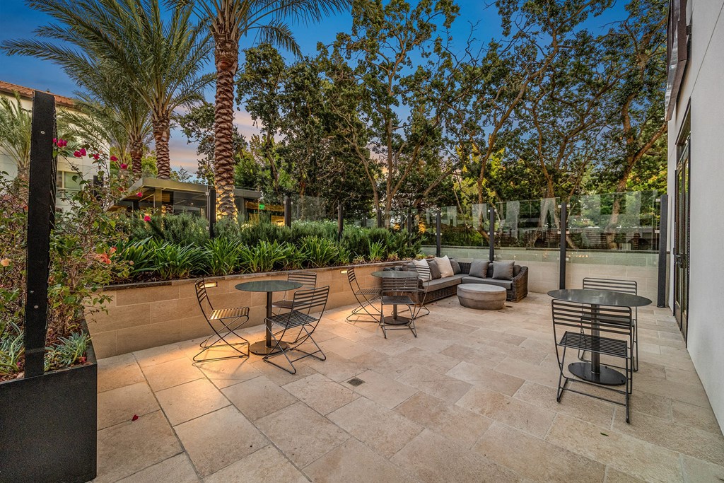 Outdoor terrace with cozy seating, lush landscaping, and intimate tables for morning coffee or evening unwinds