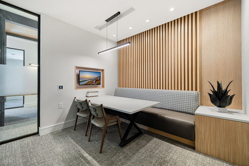 Private work suite with built-in seating, modern lighting, and digital screen for focus and productivity