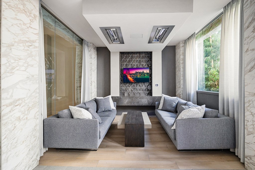 Sophisticated lounge with modern sofas, marble details, and wall-mounted TV for stylish relaxation