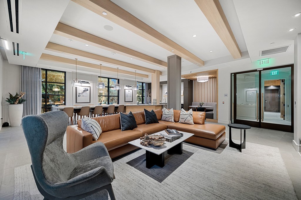 Stylish resident lounge with leather sectional, designer seating, and modern lighting for gatherings and relaxation