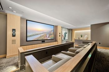 Private theater room with oversized screen, plush leather seating, and intimate lighting for movie nights