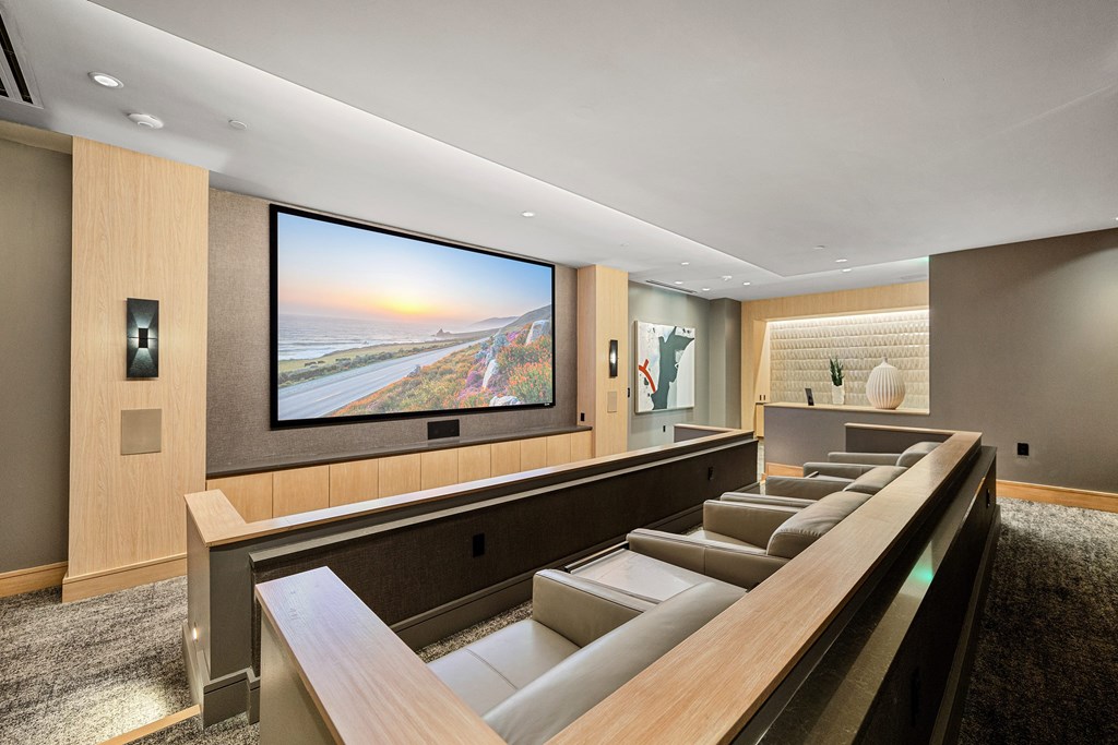 Private theater room with oversized screen, plush leather seating, and intimate lighting for movie nights