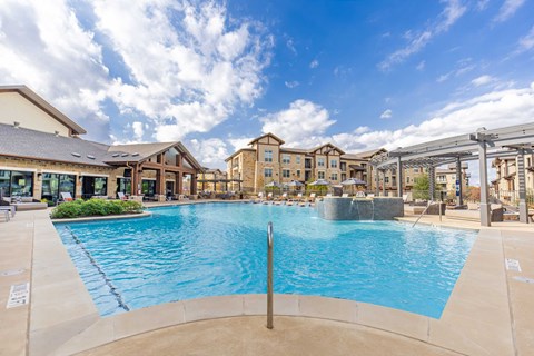 Boutique swimming pool with lounge seating and apartment buildings at The Preserve in Grapevine.
