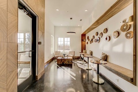 A modern living room with a long wooden bench and a long table with chairs.