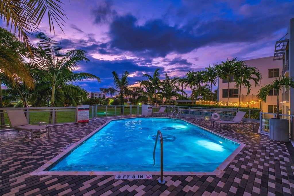 the swimming pool at the resort at sunset
